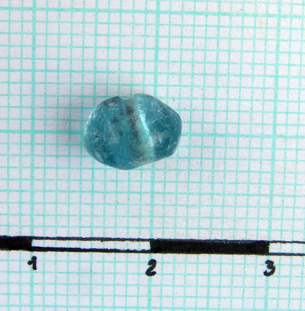 Fragment of a bluish glass paste bead (half)