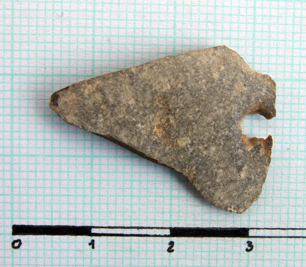 Flat perforated triangular stone object
